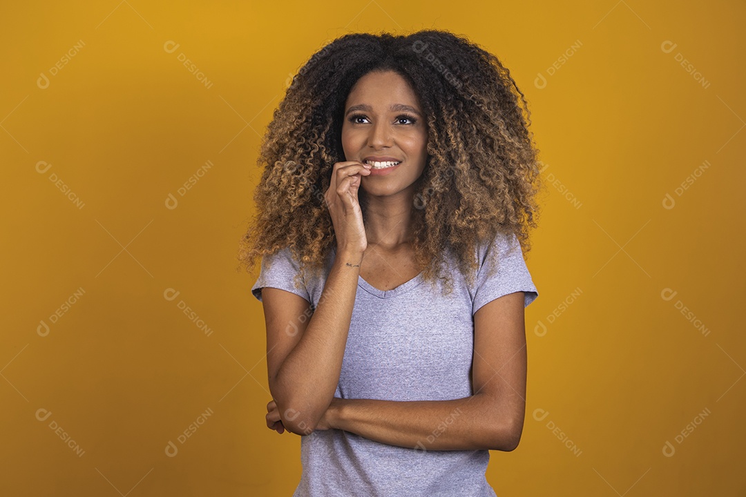 Linda mulher jovem morena cabelo afro sobre fundo isolado amarelo