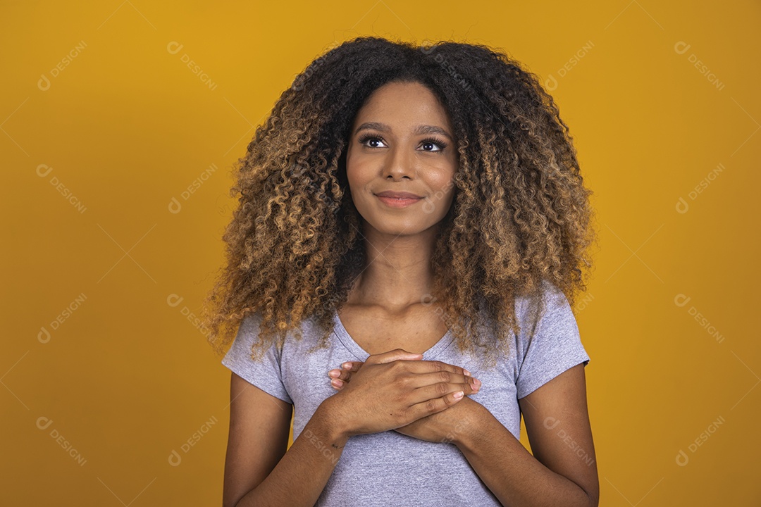 Linda mulher jovem morena cabelo afro sobre fundo isolado amarelo