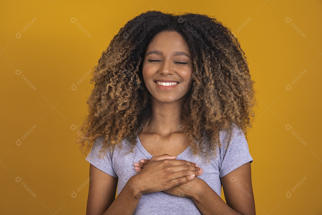 Linda mulher jovem morena cabelo afro sobre fundo isolado amarelo