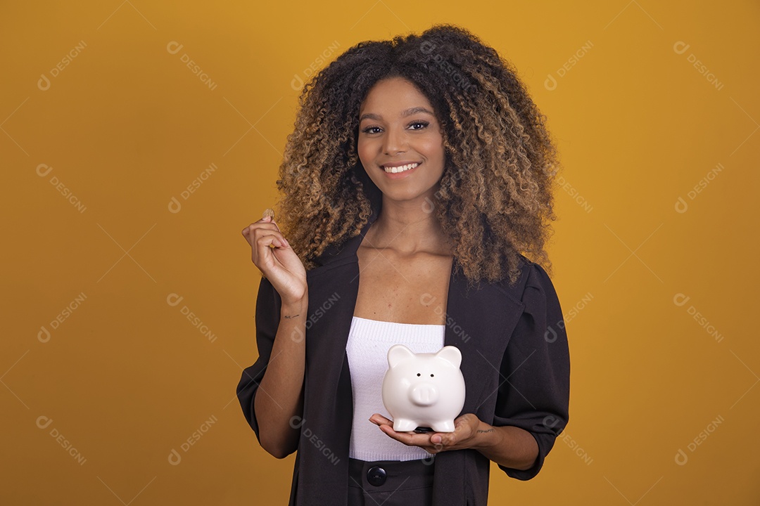 Linda mulher jovem morena cabelo afro segurando cofre sobre fundo isolado amarelo