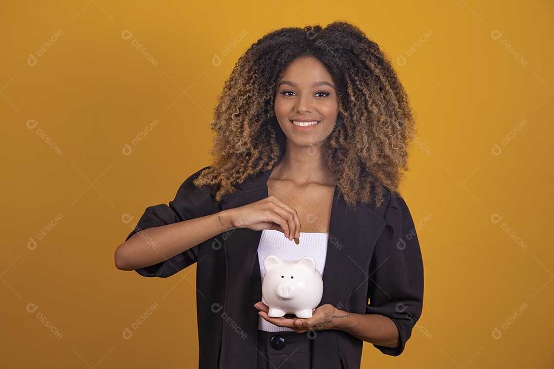 Linda mulher jovem morena cabelo afro segurando cofre sobre fundo isolado amarelo