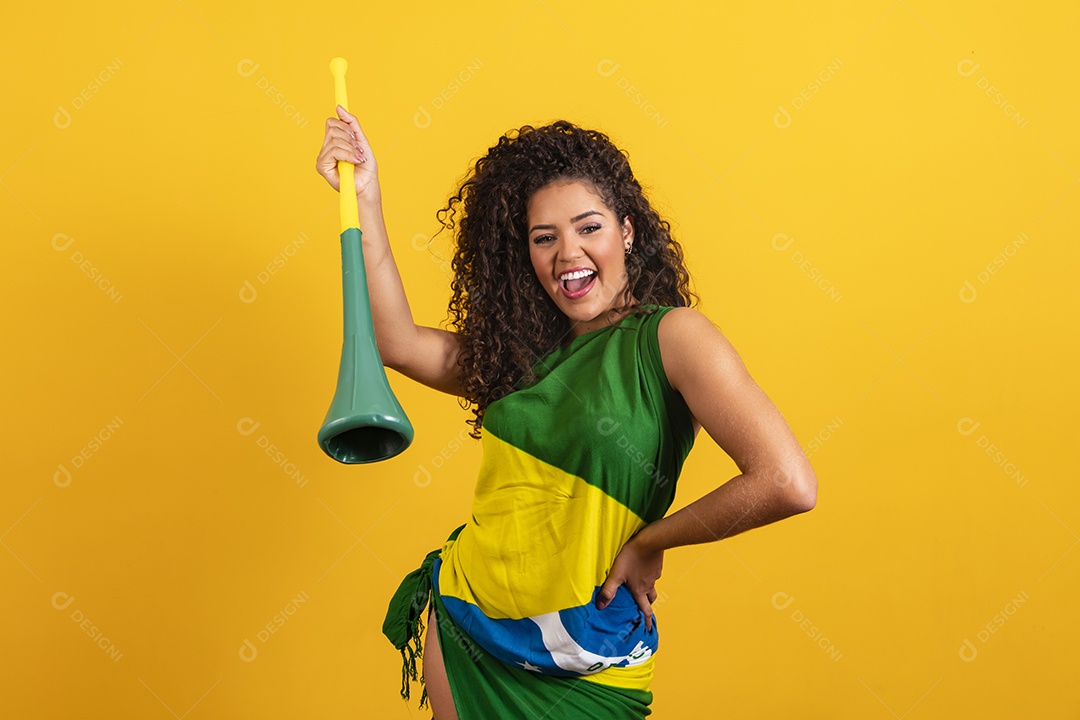 Linda mulher jovem torcedora morena brasileira cabelo cacheado sobre fundo isolado amarelo