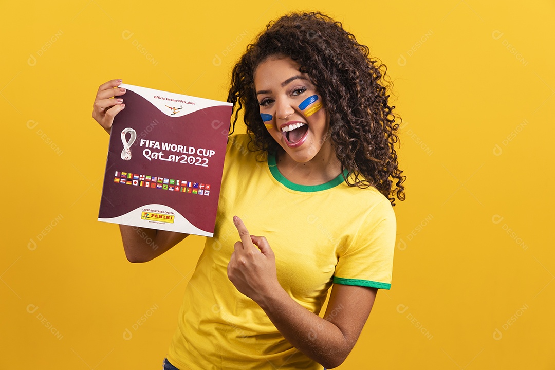 Linda mulher jovem morena segurando álbum da copa do brasil de 2022 futebol