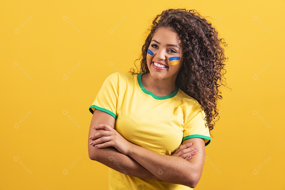 Linda mulher jovem morena segurando bandeira do brasil cabelo afro sobre fundo isolado amarelo