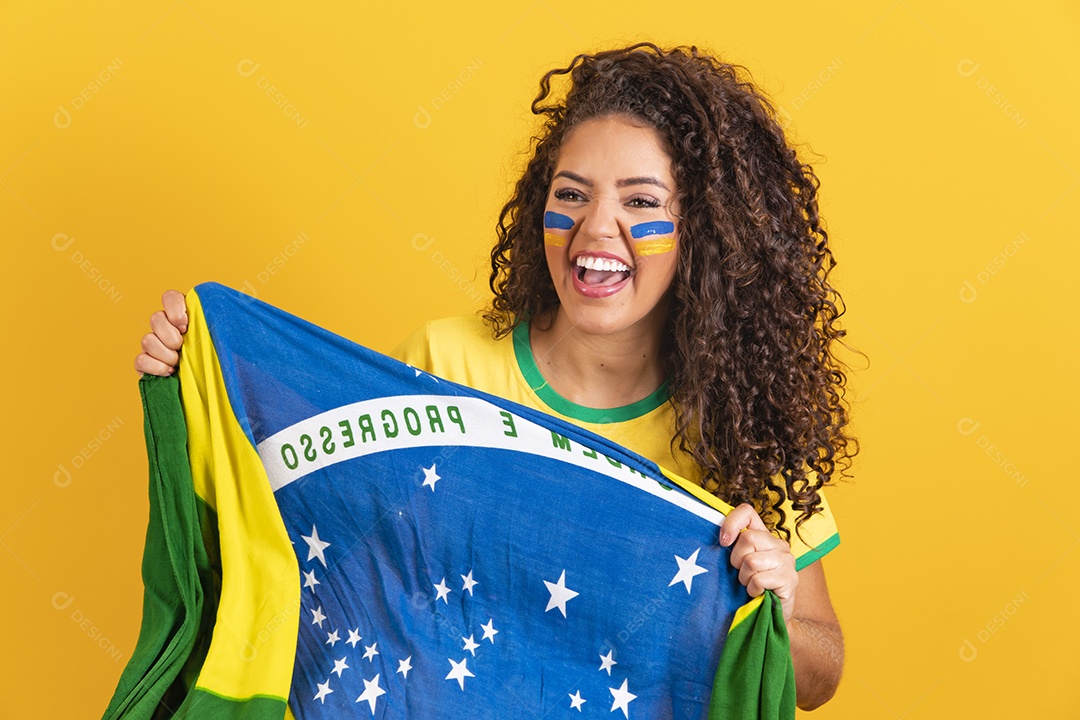 Linda mulher jovem morena segurando bandeira do brasil cabelo afro sobre fundo isolado amarelo