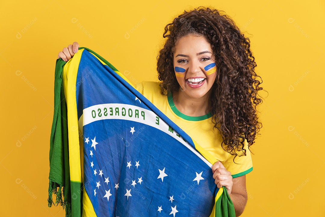 Linda mulher jovem morena segurando bandeira do brasil cabelo afro sobre fundo isolado amarelo