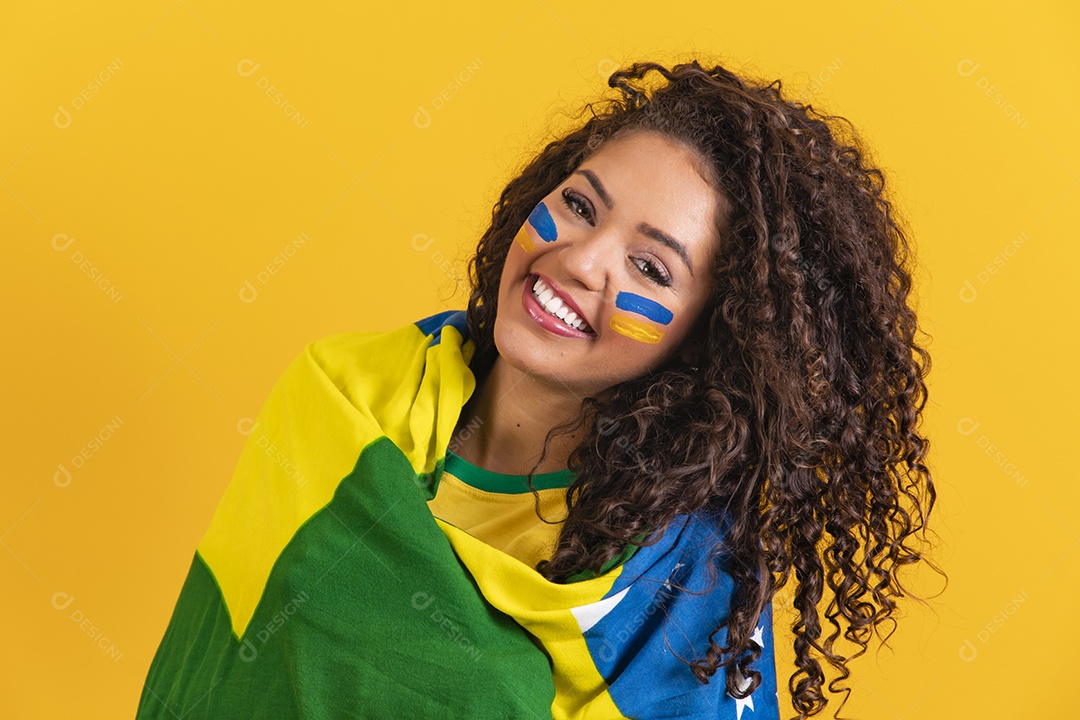 Linda mulher jovem morena segurando bandeira do brasil cabelo afro sobre fundo isolado amarelo