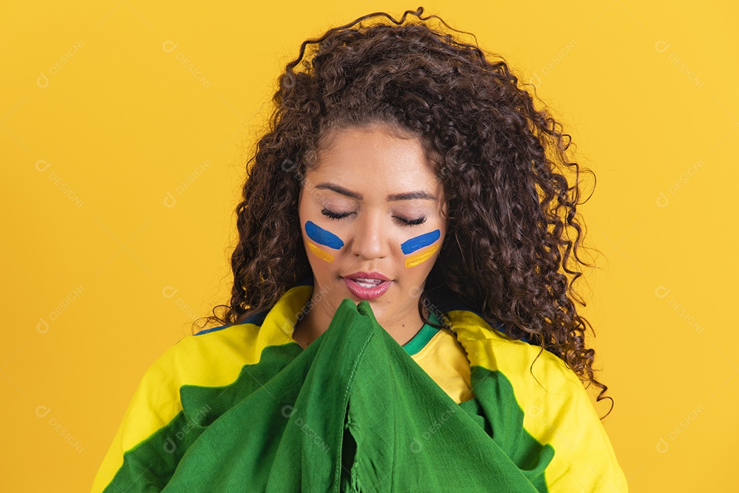 Linda mulher jovem morena segurando bandeira do brasil cabelo afro sobre fundo isolado amarelo