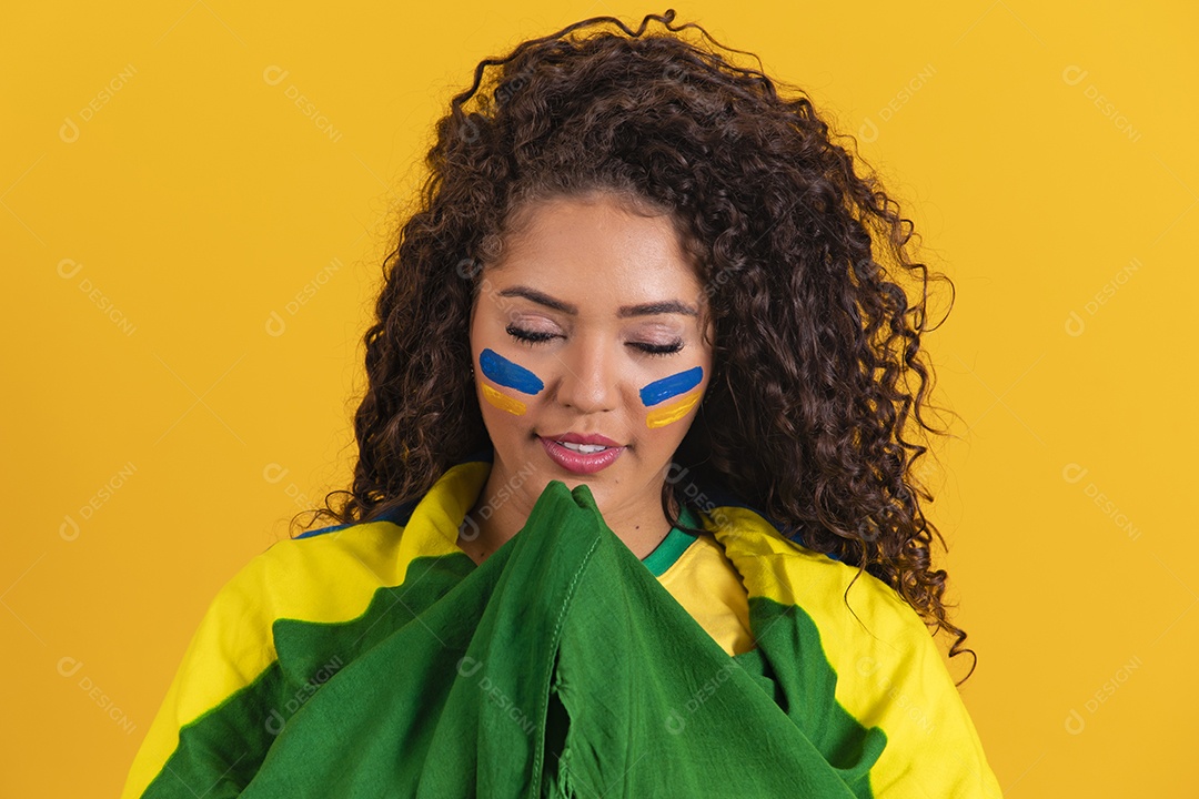 Linda mulher jovem morena segurando bandeira do brasil cabelo afro sobre fundo isolado amarelo