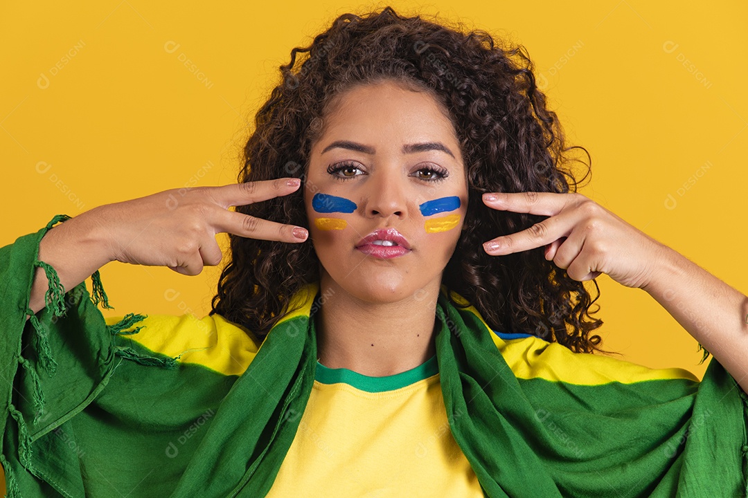 Linda mulher jovem morena segurando bandeira do brasil cabelo afro sobre fundo isolado amarelo