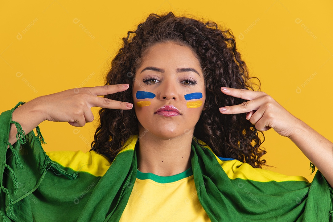 Linda mulher jovem morena segurando bandeira do brasil cabelo afro sobre fundo isolado amarelo
