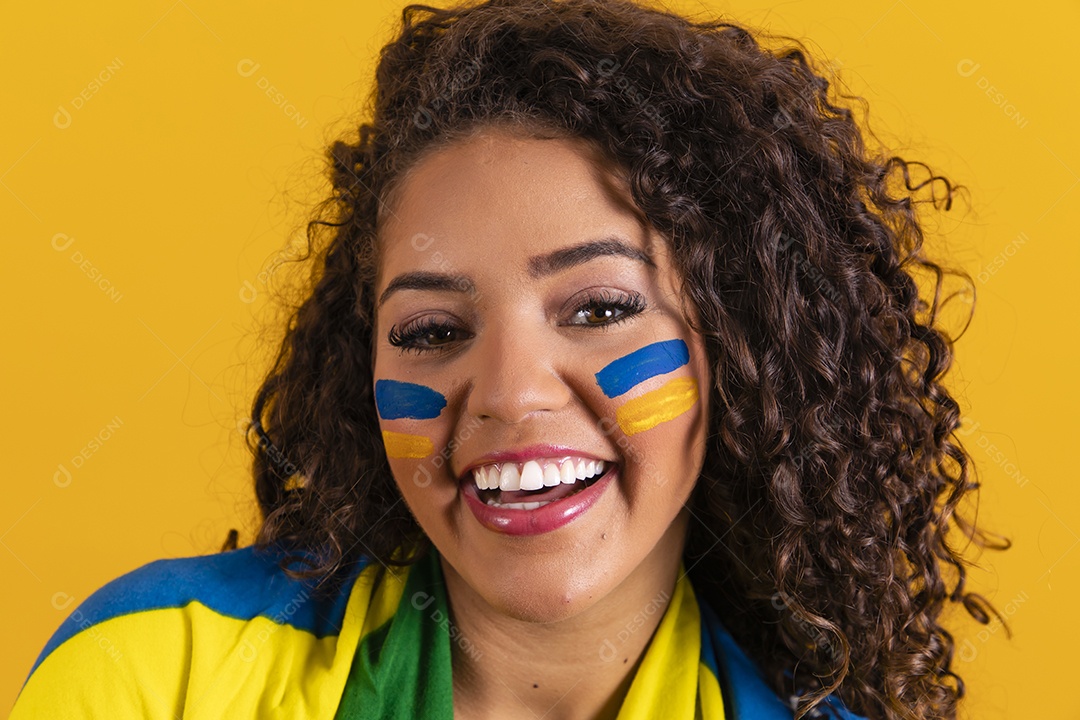 Linda mulher jovem morena segurando bandeira do brasil cabelo afro sobre fundo isolado amarelo