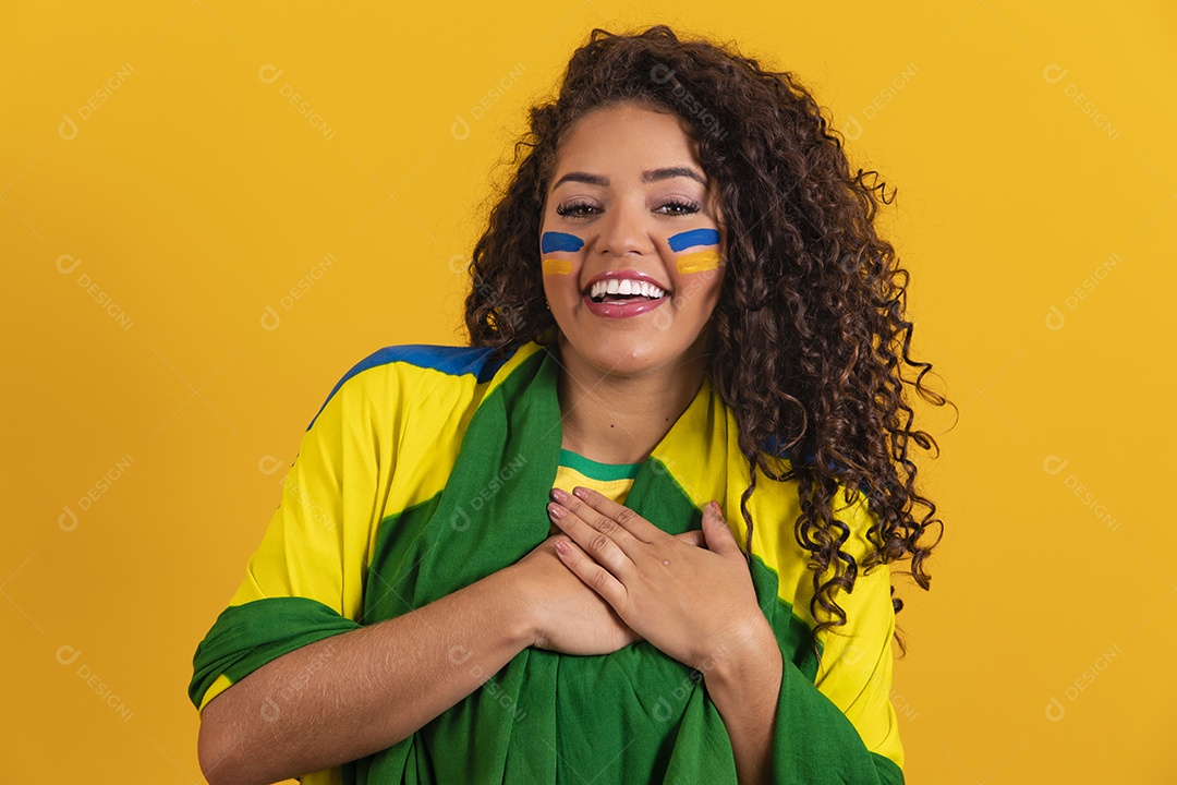 Linda mulher jovem morena segurando bandeira do brasil cabelo afro sobre fundo isolado amarelo
