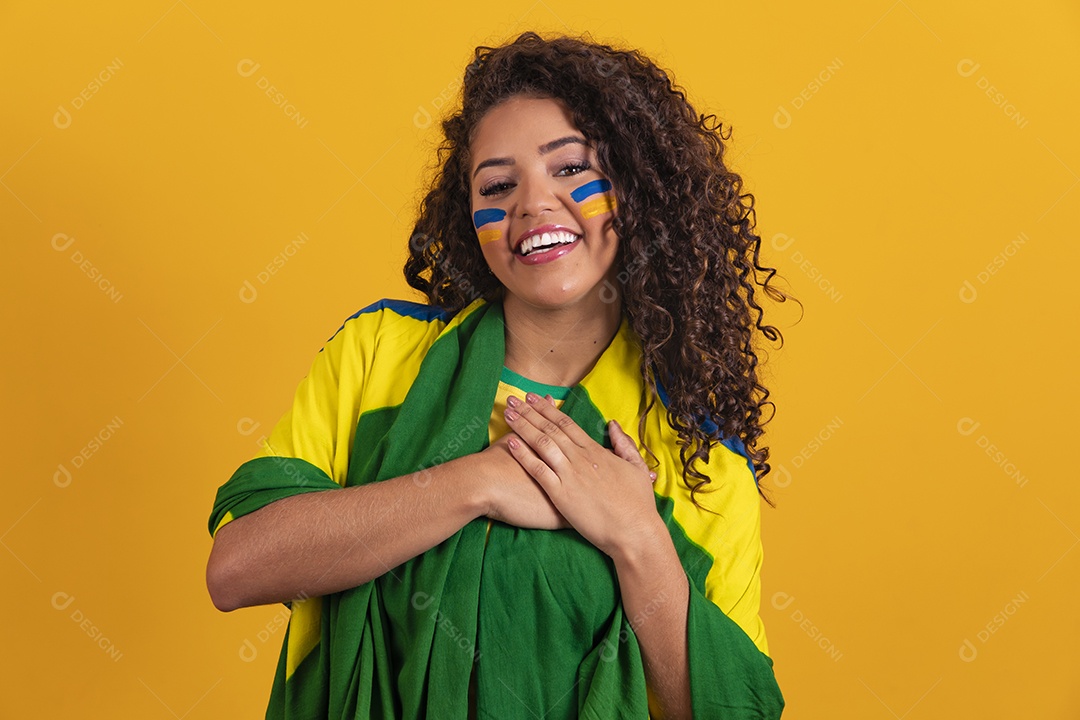 Linda mulher jovem morena segurando bandeira do brasil cabelo afro sobre fundo isolado amarelo