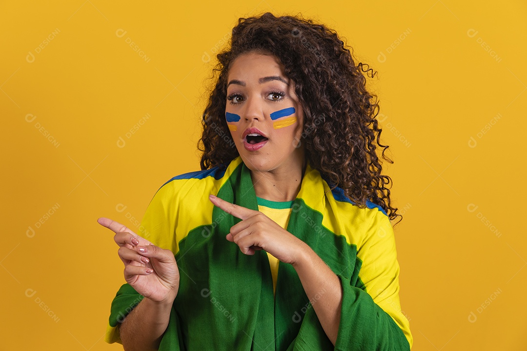 Linda mulher jovem morena segurando bandeira do brasil cabelo afro sobre fundo isolado amarelo