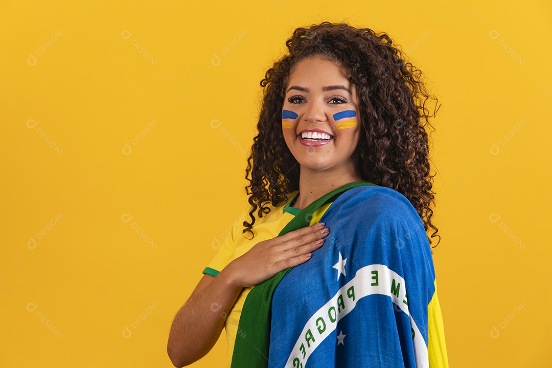 Linda mulher jovem morena segurando bandeira do brasil cabelo afro sobre fundo isolado amarelo