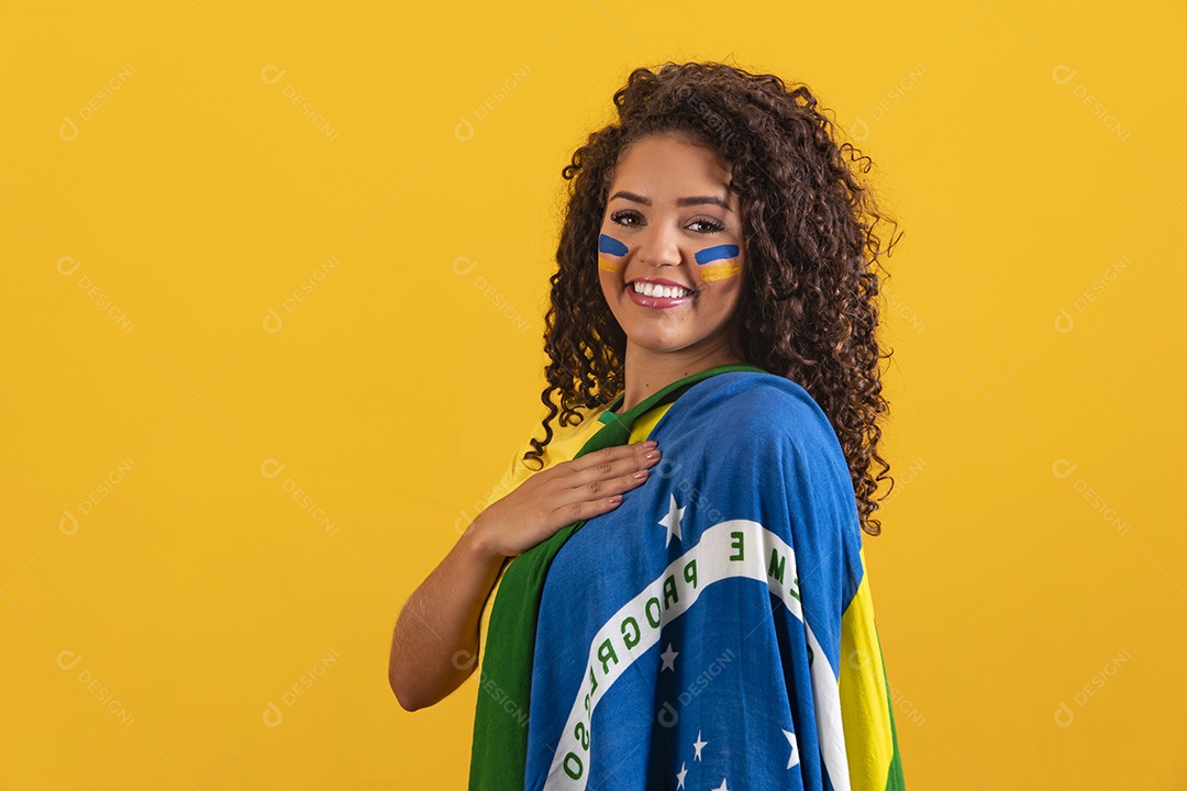 Linda mulher jovem morena segurando bandeira do brasil cabelo afro sobre fundo isolado amarelo