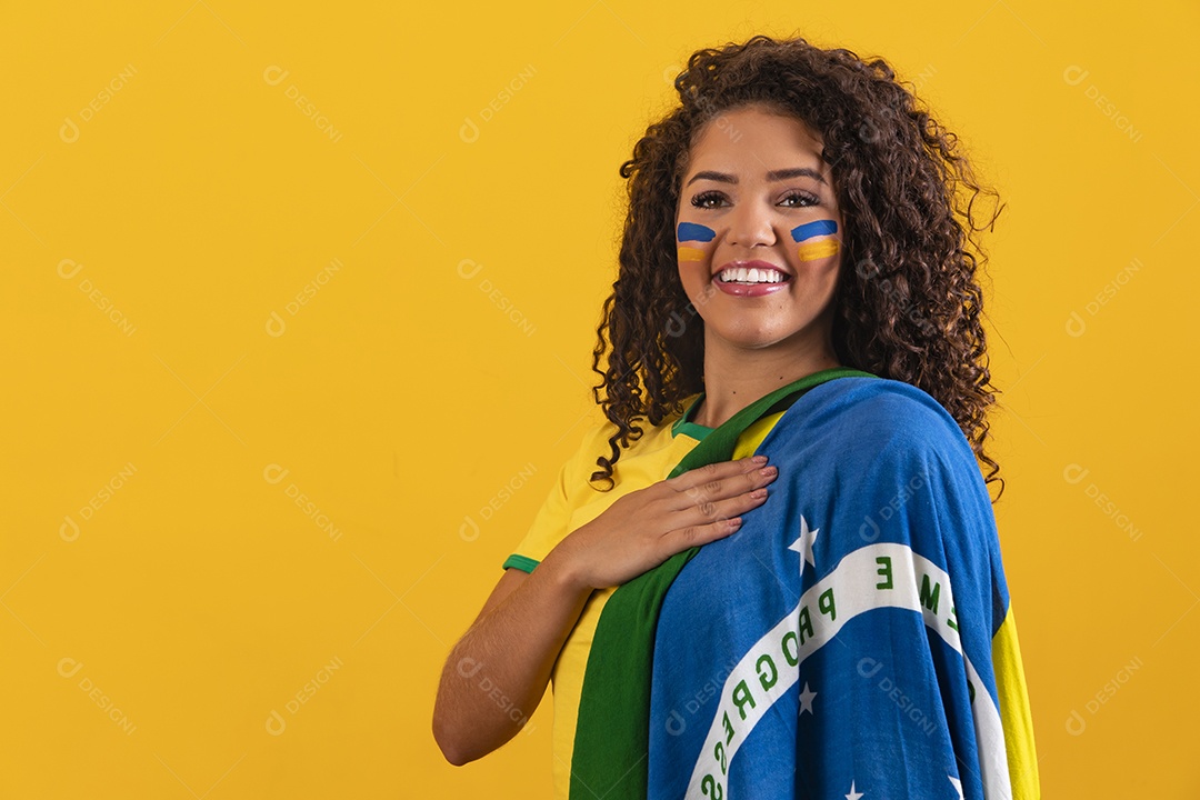 Linda mulher jovem morena segurando bandeira do brasil cabelo afro sobre fundo isolado amarelo