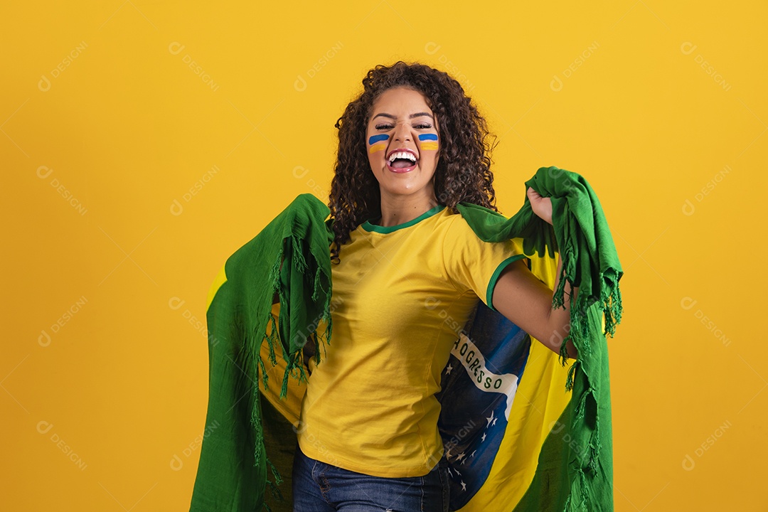 Linda mulher jovem morena segurando bandeira do brasil cabelo afro sobre fundo isolado amarelo