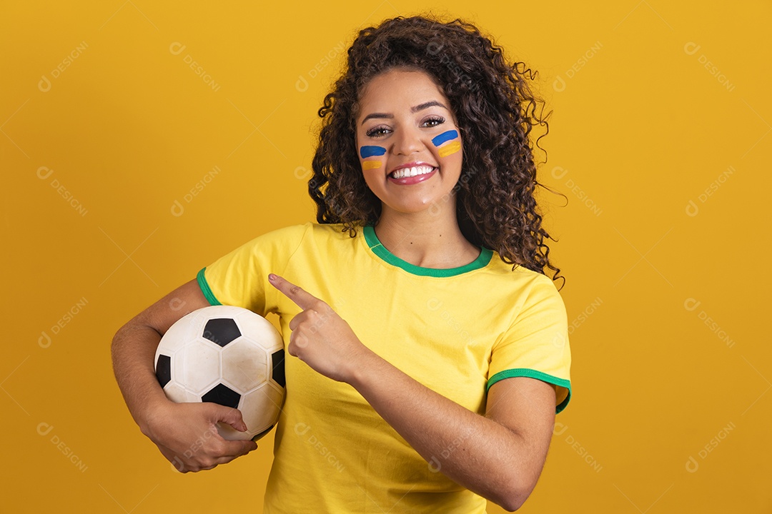 Linda mulher jovem morena segurando bandeira do brasil cabelo afro sobre fundo isolado amarelo