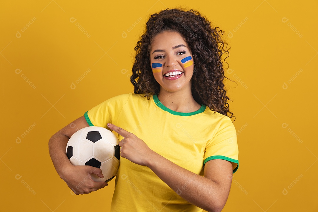 Linda mulher jovem morena segurando bandeira do brasil cabelo afro sobre fundo isolado amarelo