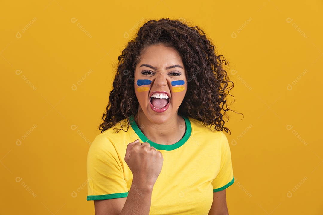 Linda mulher jovem morena segurando bandeira do brasil cabelo afro sobre fundo isolado amarelo