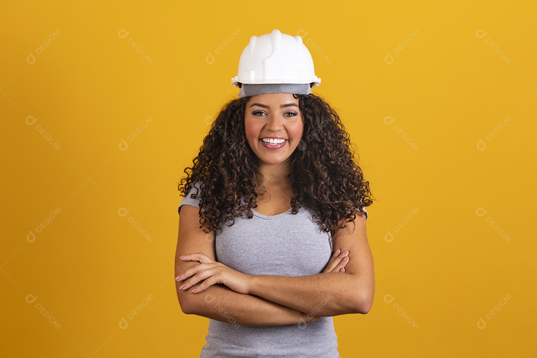 Linda mulher jovem garota cabelo cacheado engenheira usando capacete branco fundo isolado amarelo