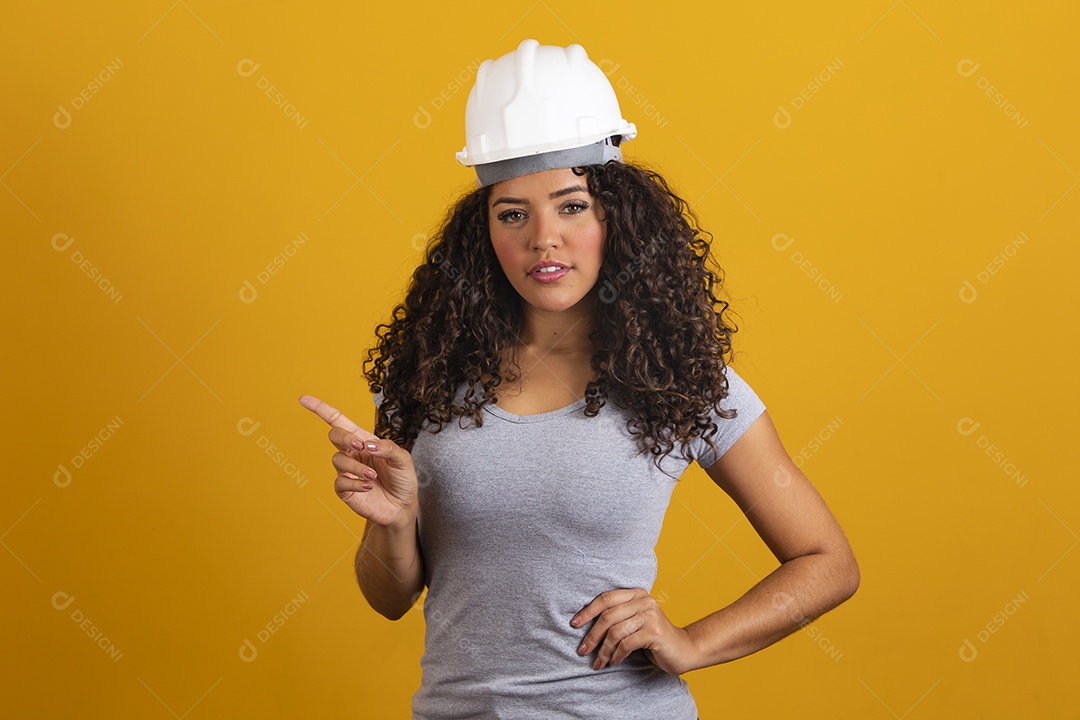 Linda mulher jovem garota cabelo cacheado engenheira usando capacete branco fundo isolado amarelo