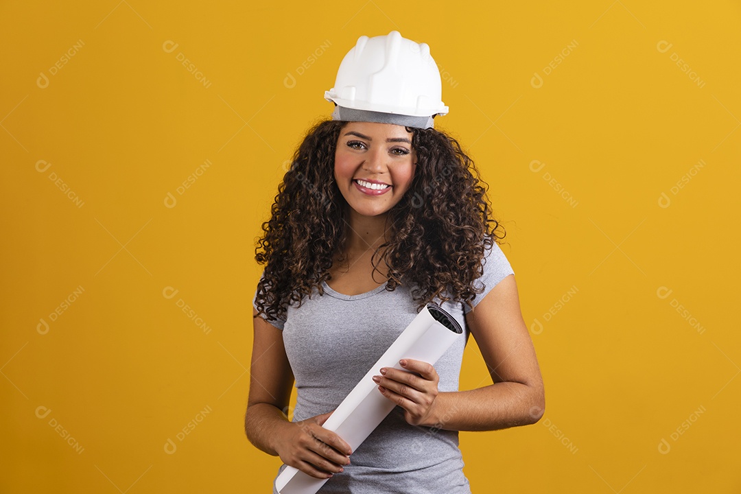 Linda mulher jovem garota cabelo cacheado engenheira usando capacete segurando projeto planta branco fundo isolado amarelo