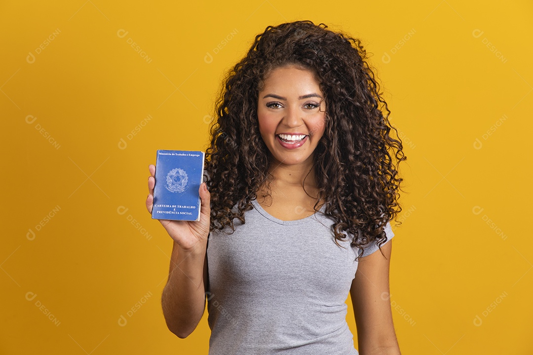 Beautiful young curly hair woman holding workbook over yellow isolated background