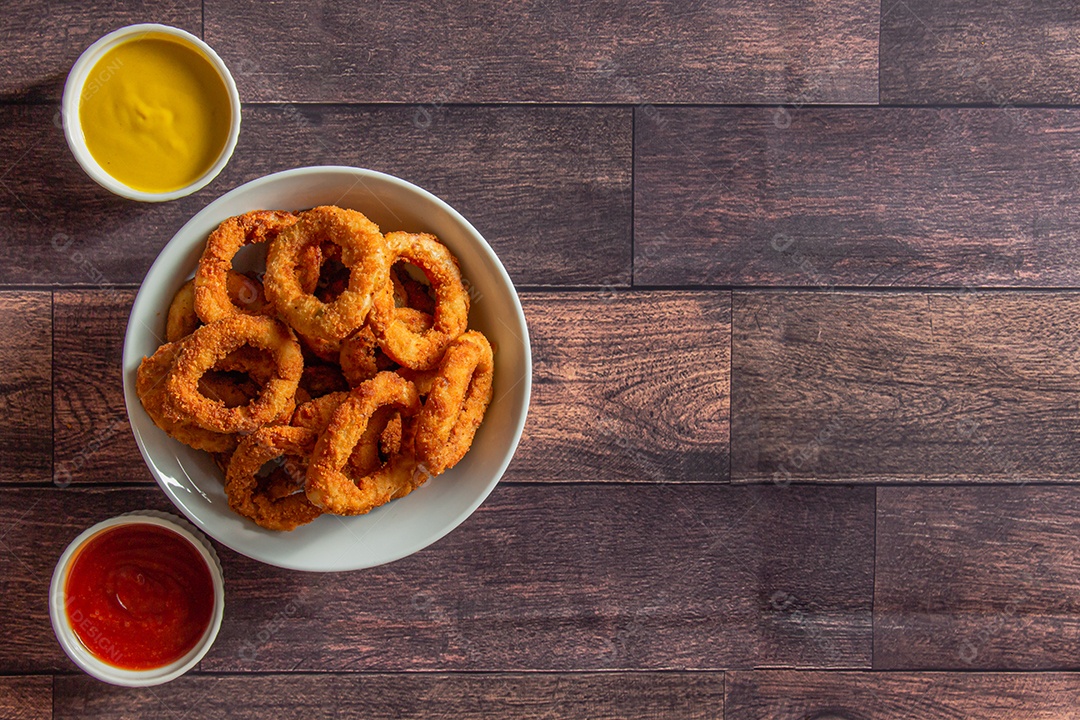 Anéis de cebola comida sobre uma mesa de madeira