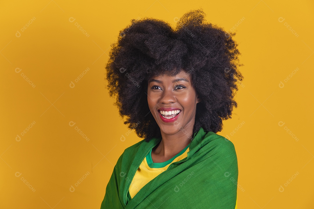 Linda mulher jovem morena torcedora do brasil cabelo afro usando camiseta do brasil sobre fundo isolado amarelo