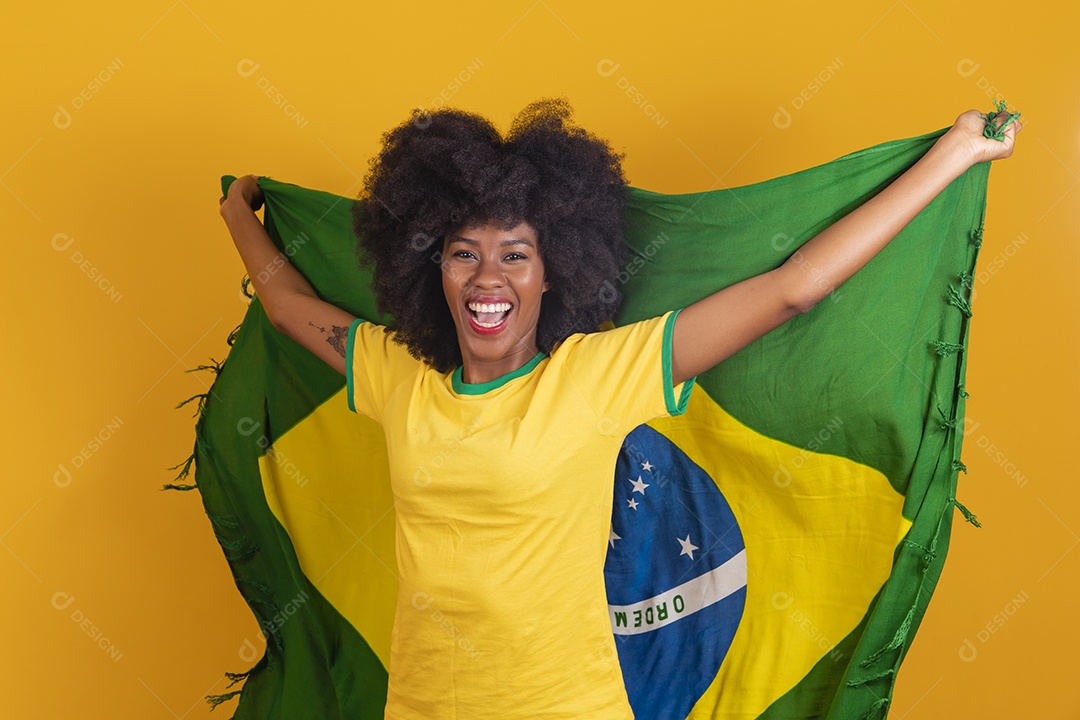 Linda mulher jovem morena torcedora do brasil cabelo afro usando camiseta do brasil sobre fundo isolado amarelo