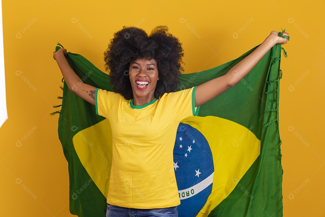 Linda mulher jovem morena segurando bandeira do brasil cabelo afro sobre fundo isolado amarelo