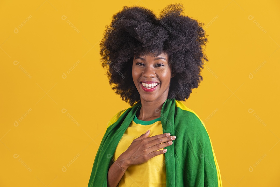 Linda mulher jovem morena segurando bandeira do brasil cabelo afro sobre fundo isolado amarelo