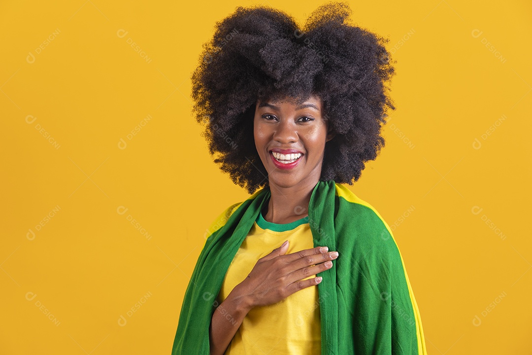 Linda mulher jovem morena segurando bandeira do brasil cabelo afro sobre fundo isolado amarelo