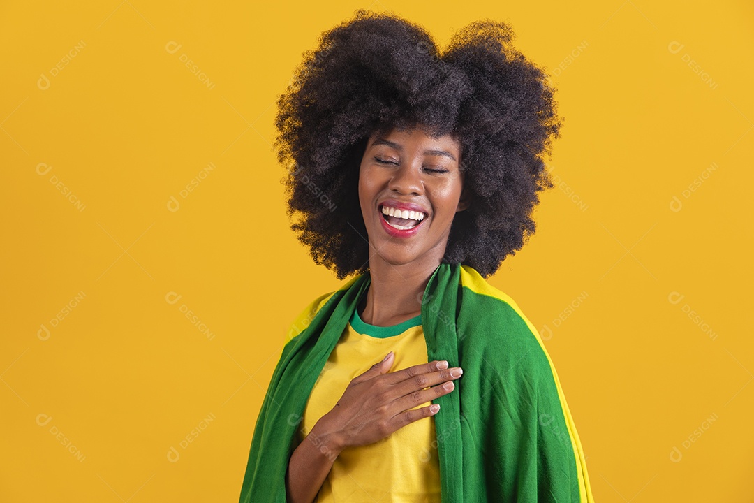 Linda mulher jovem morena segurando bandeira do brasil cabelo afro sobre fundo isolado amarelo