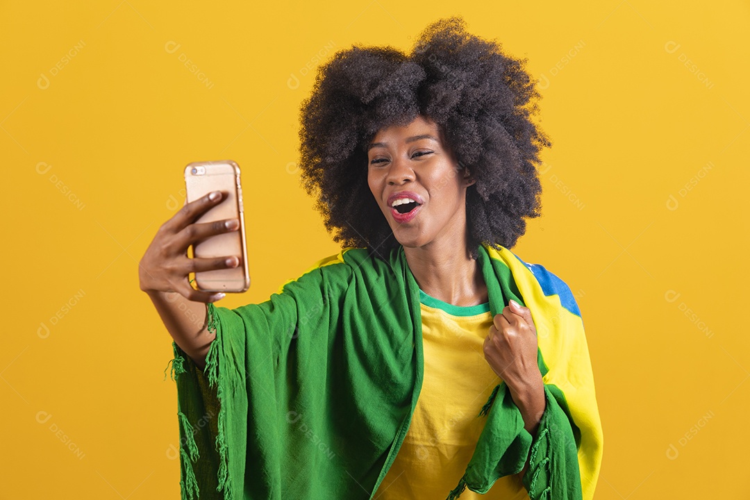 Linda mulher jovem morena segurando bandeira do brasil cabelo afro sobre fundo isolado amarelo