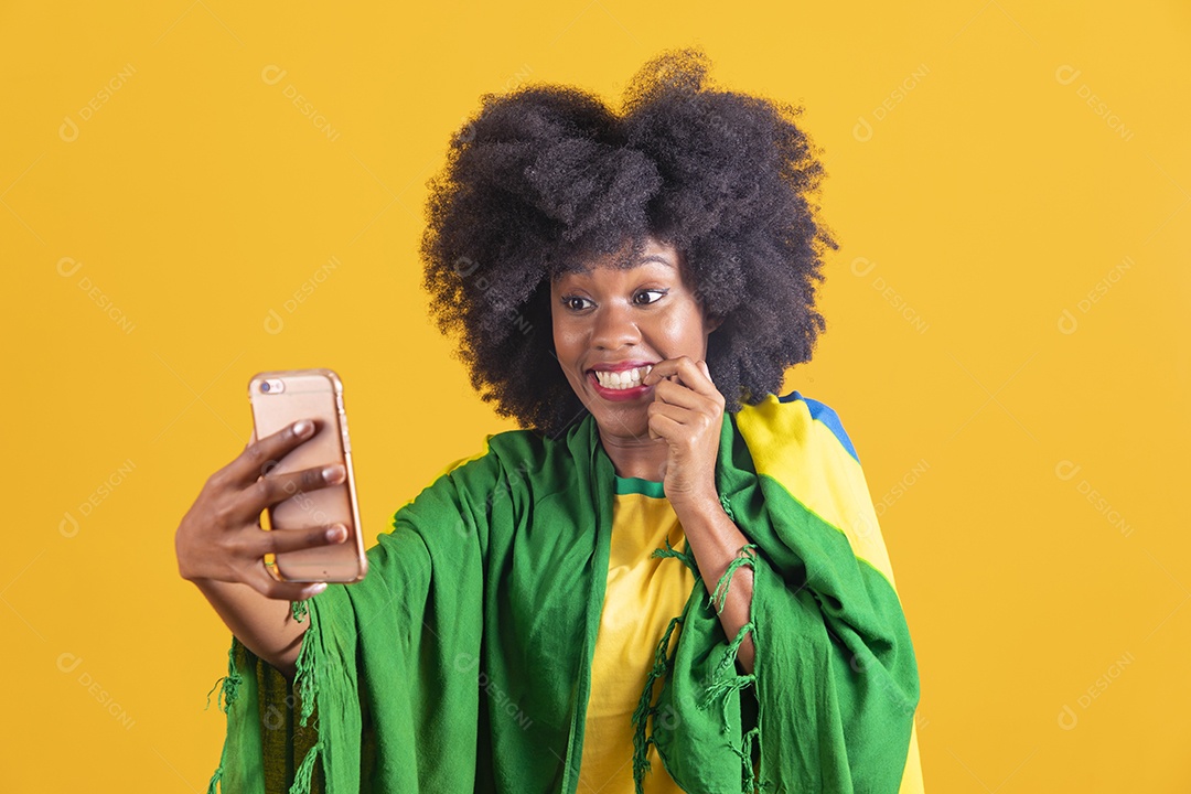 Linda mulher jovem morena segurando bandeira do brasil cabelo afro sobre fundo isolado amarelo