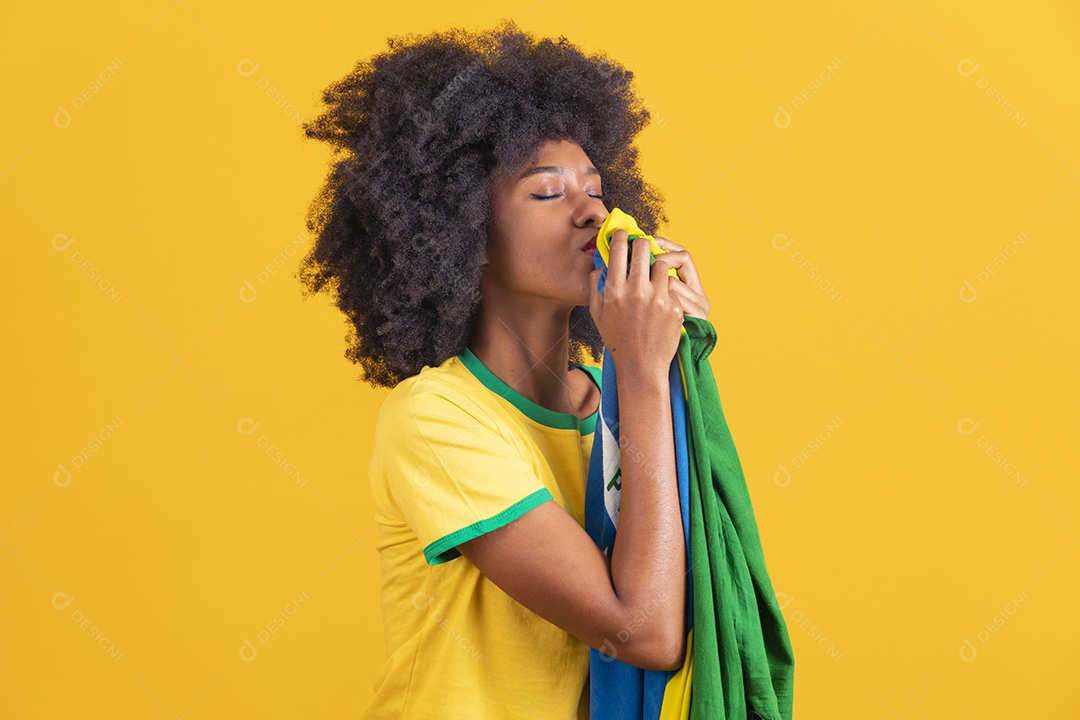 Linda mulher jovem morena segurando bandeira do brasil cabelo afro sobre fundo isolado amarelo