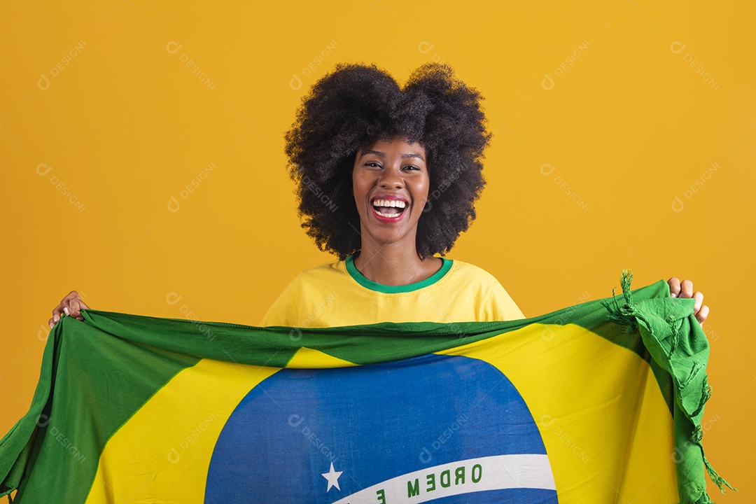 Linda mulher jovem morena torcedora do brasil cabelo afro usando camiseta do brasil sobre fundo isolado amarelo