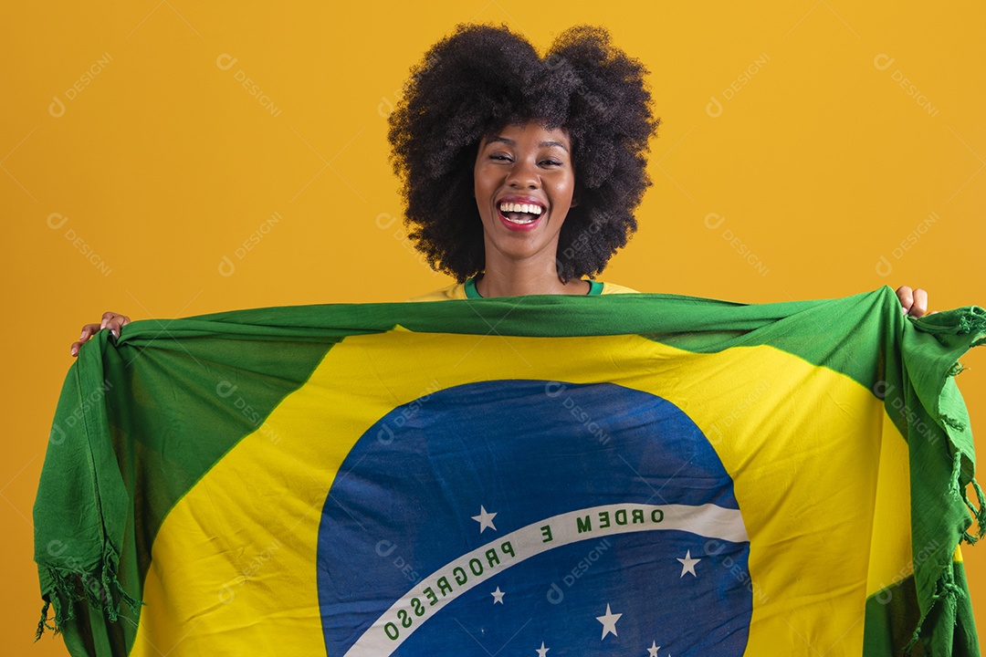 Linda mulher jovem morena torcedora do brasil cabelo afro usando camiseta do brasil sobre fundo isolado amarelo