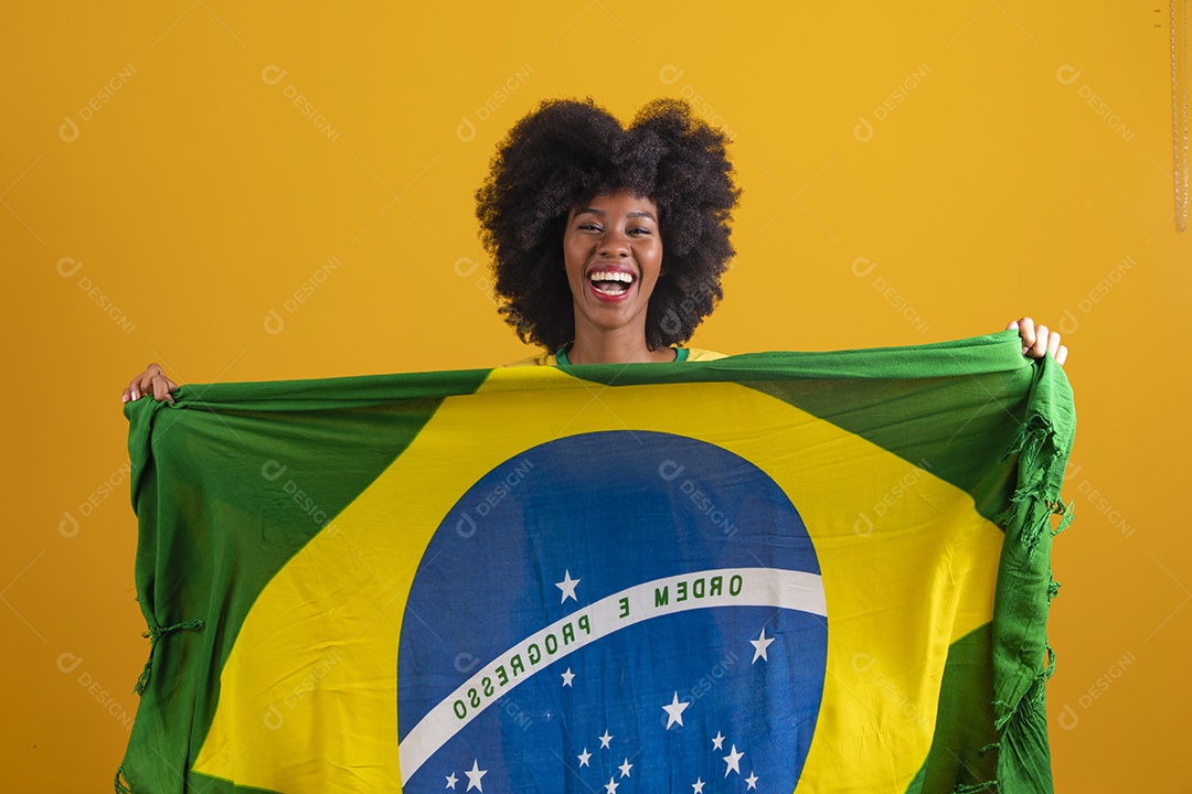 Linda mulher jovem morena torcedora do brasil cabelo afro usando camiseta do brasil sobre fundo isolado amarelo