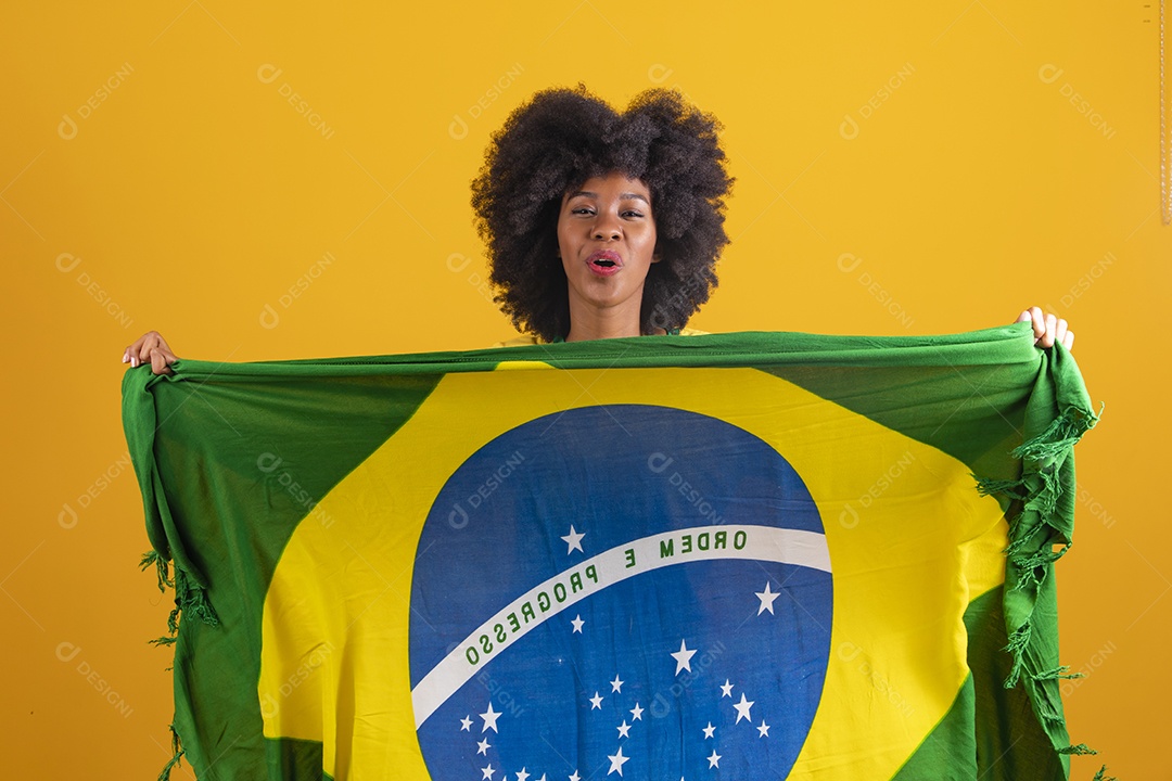 Linda mulher jovem morena torcedora do brasil cabelo afro usando camiseta do brasil sobre fundo isolado amarelo