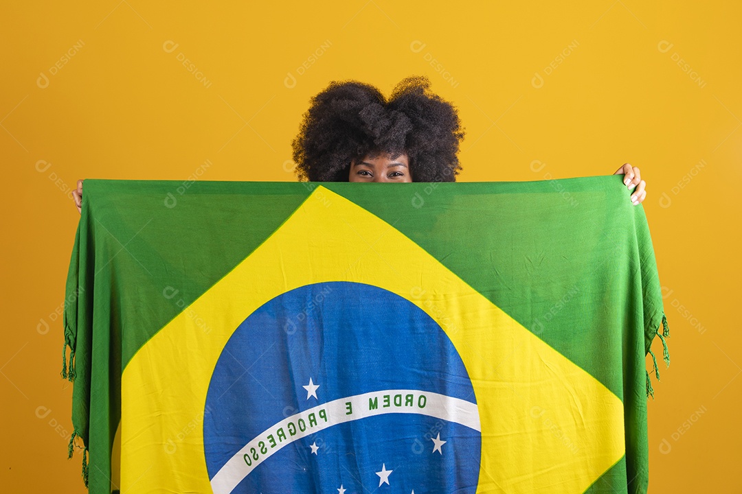 Linda mulher jovem morena segurando bandeira do brasil cabelo afro sobre fundo isolado amarelo