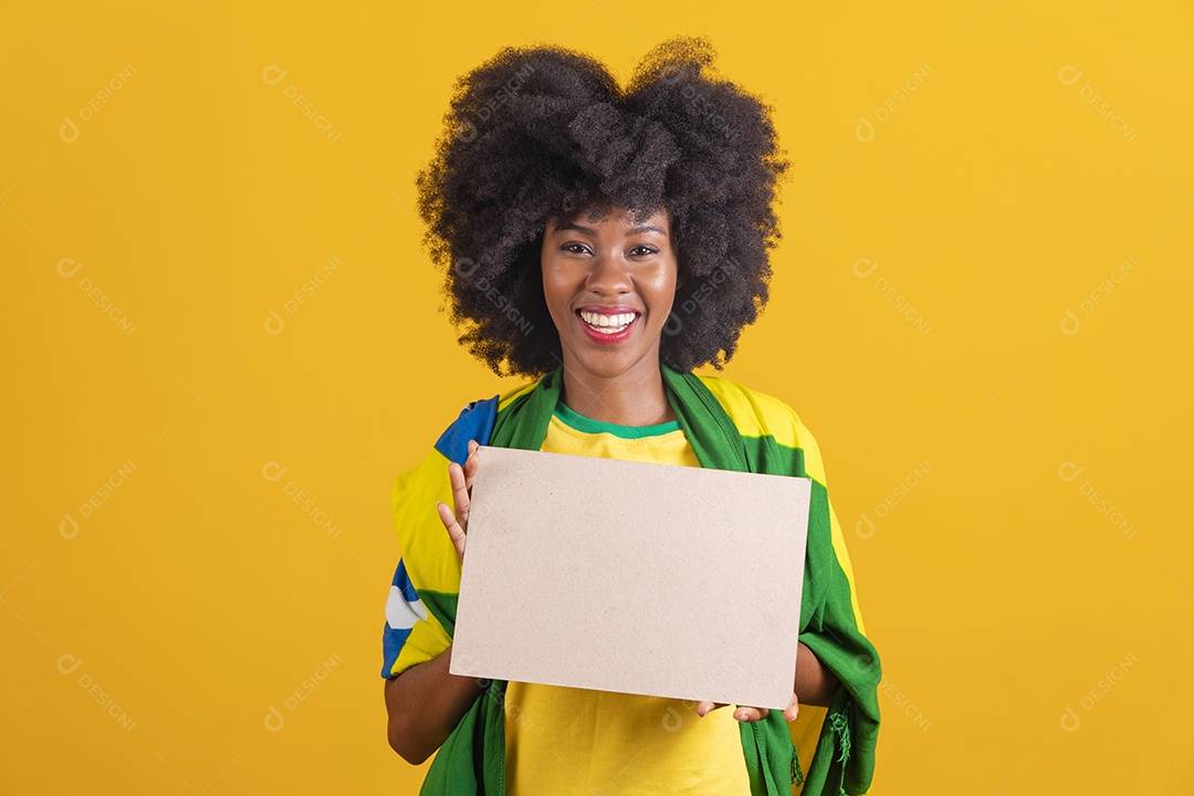 Linda mulher jovem morena segurando bandeira do brasil cabelo afro sobre fundo isolado amarelo