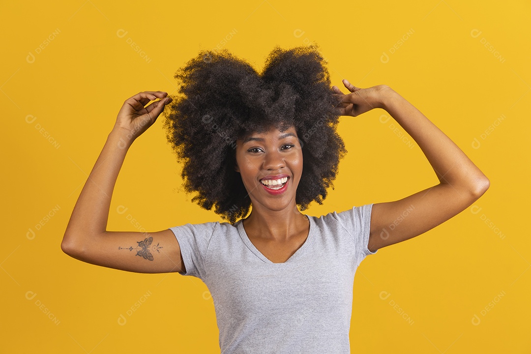 Mulher jovem morena cabelo cacheado sobre fundo isolado amarelo