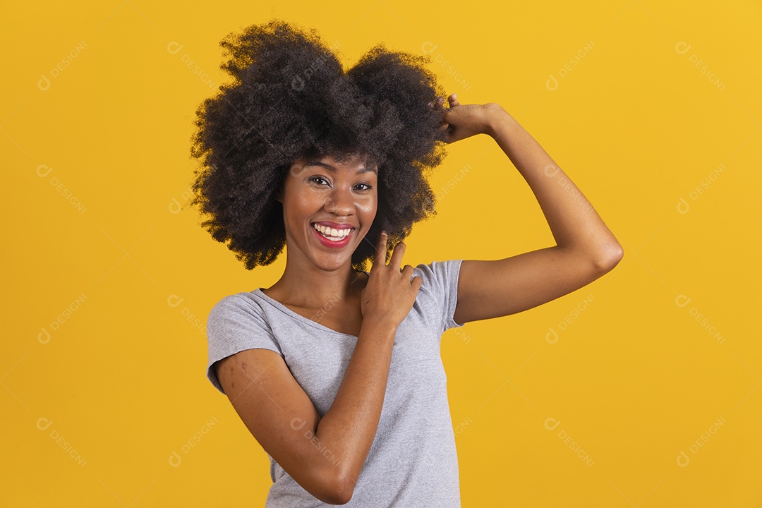 Mulher jovem morena cabelo cacheado sobre fundo isolado amarelo