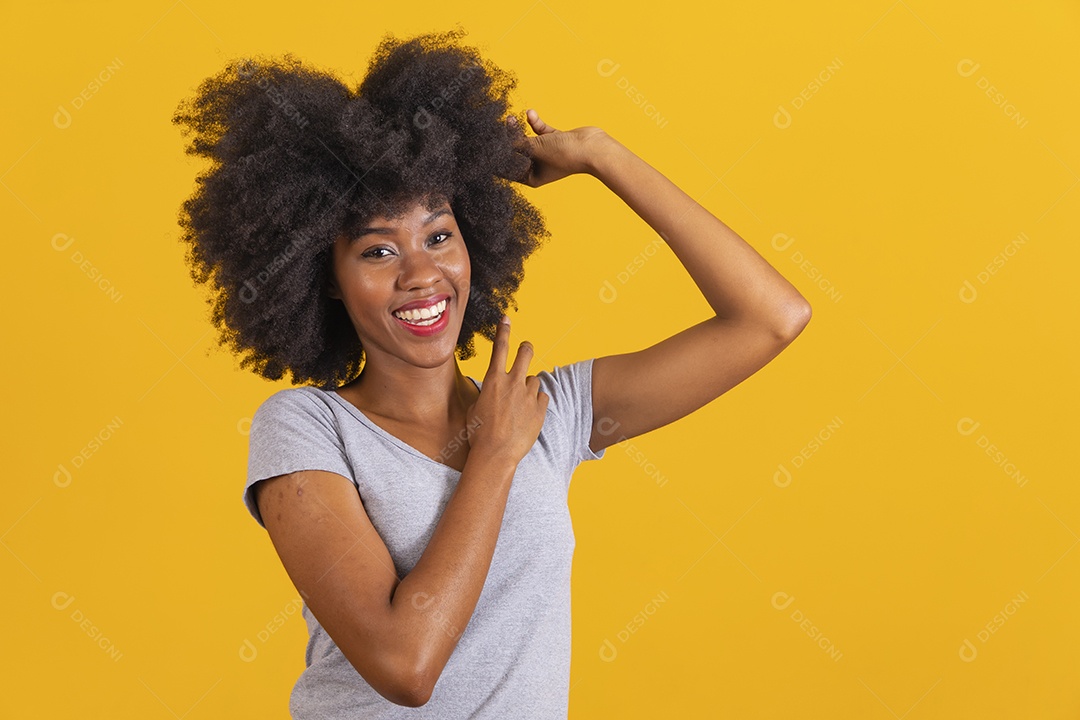 Mulher jovem morena cabelo cacheado sobre fundo isolado amarelo
