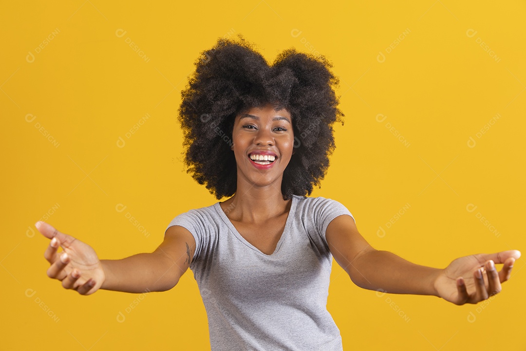 Mulher jovem morena cabelo cacheado sobre fundo isolado amarelo